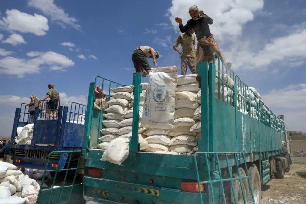 Photo de personnes qui font partis d'une aides humanitaires avec des sacs de nourritures 